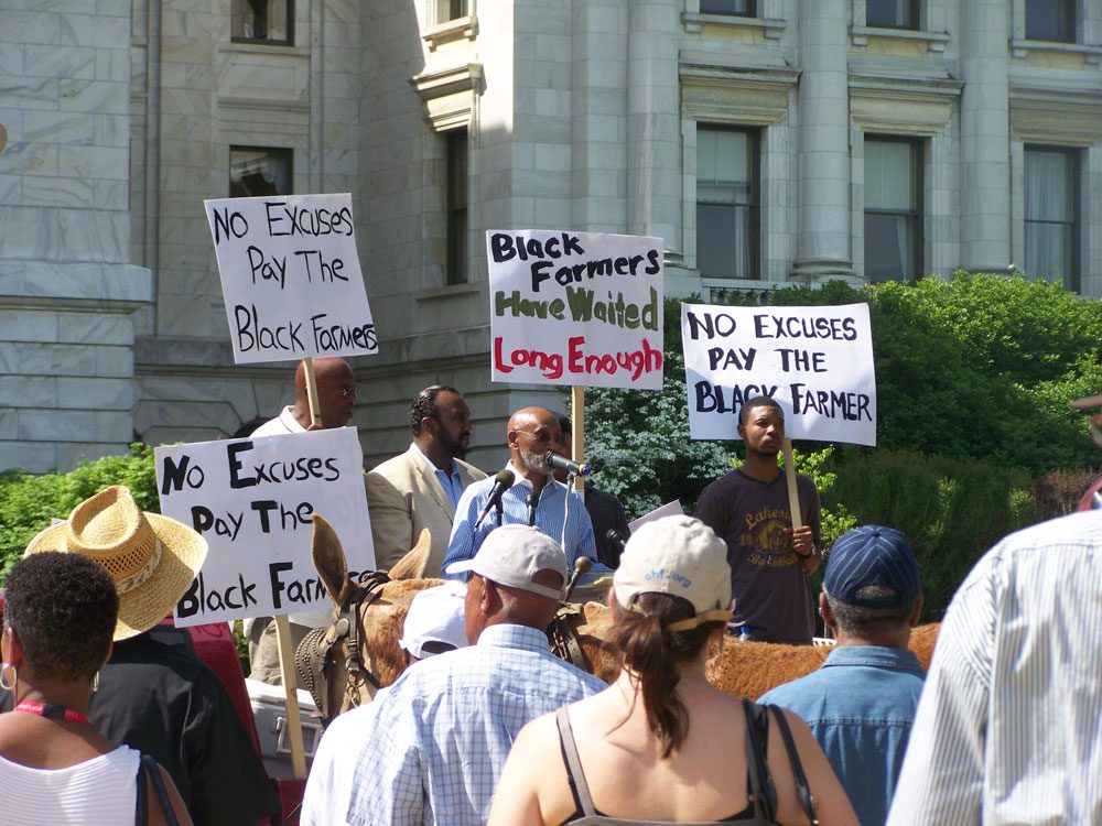 Manifestantes con carteles para el caso Pigford II - Black Farmers
