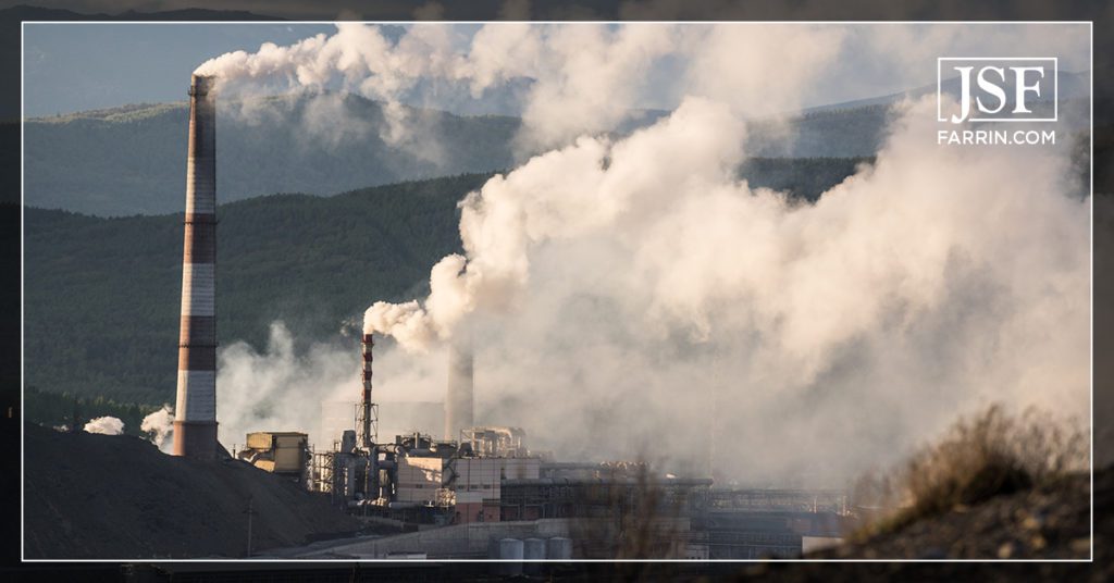 Exterior view of paper mill pipes emitting a considerable amount of air pollution.