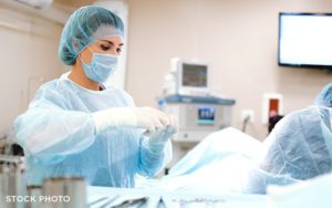 A surgeon in the operating room working on a patient in a hospital.