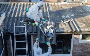 Professionals cleaning out old roofing containing asbestos.