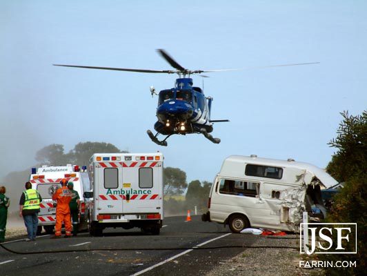 medical helicopter about to land near an ambulance and car accident scene