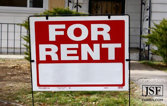 Red for rent sign in front of a house
