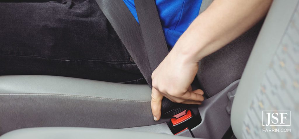 car passenger in the motion of fastening seatbelt