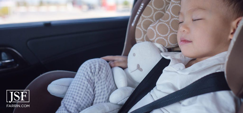 Toddler boy sleeping in modern car seat