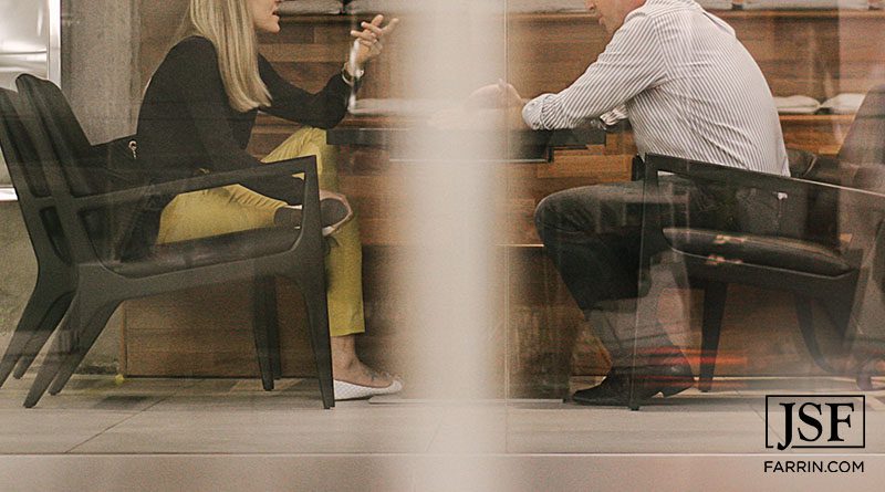 A man and woman having a serious conversation behind a window
