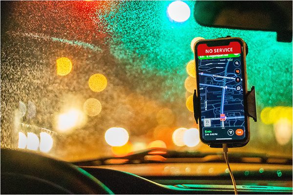 A cell phone on the windshield of a car during a storm with no signal on the GPS.