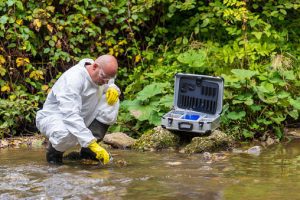 man in safety equipment checks water for GenX