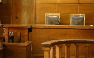 Empty chairs and bench with a microphone in a courtroom.