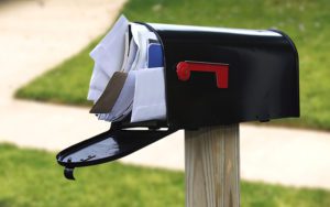 A mailbox packed with letters and overdue bills.
