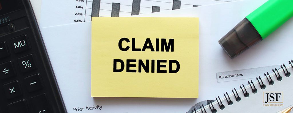 Denied form label laying on a desk. If your claim is denied, you have the right to request a hearing