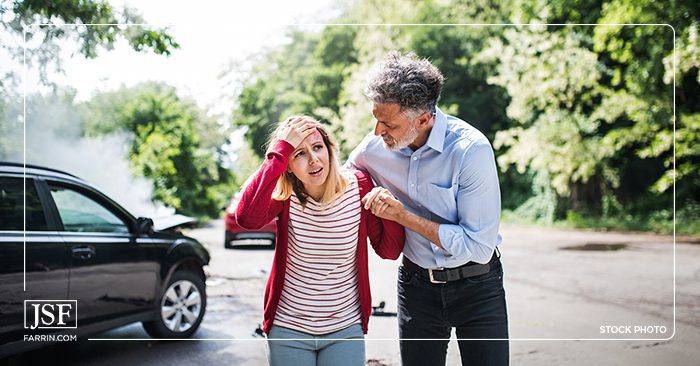  A man comforting a traumatized woman after her car accident.