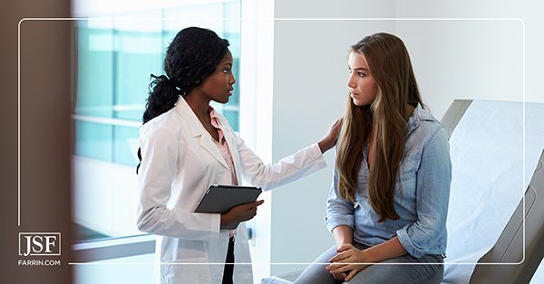 Young woman talking to a female doctor at her gynecologist's office.