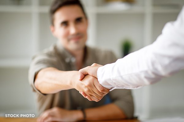Client shaking hands with an attorney in an office.