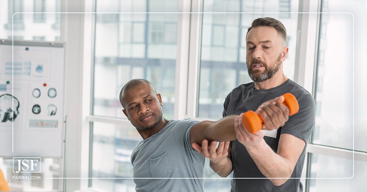 Physical therapist helping a patient lift a weight during a therapy session.