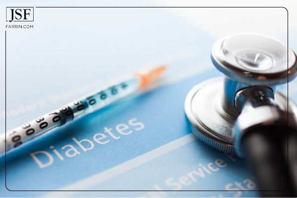 A stethoscope and insulin needle rest on a diabetes pamphlet.