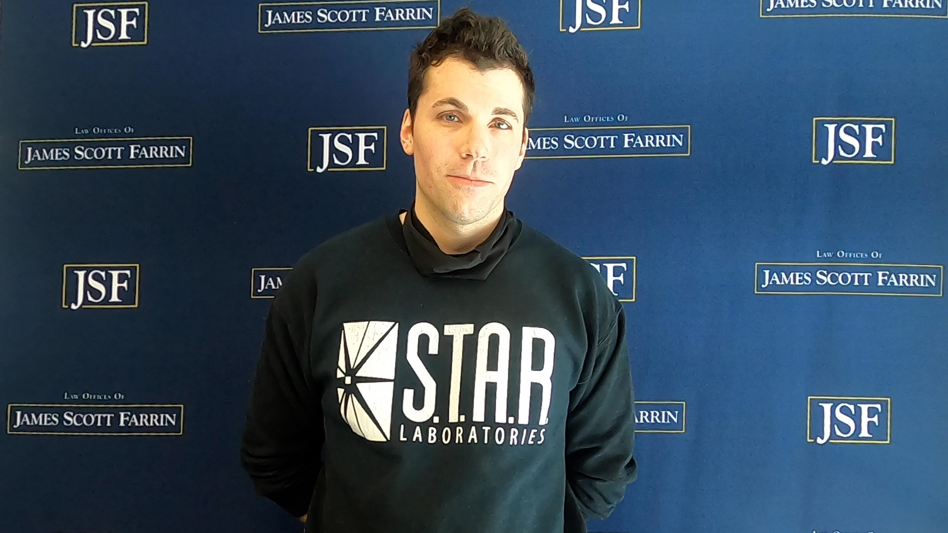 Graham Lardieri standing in front of a JSF blue background.