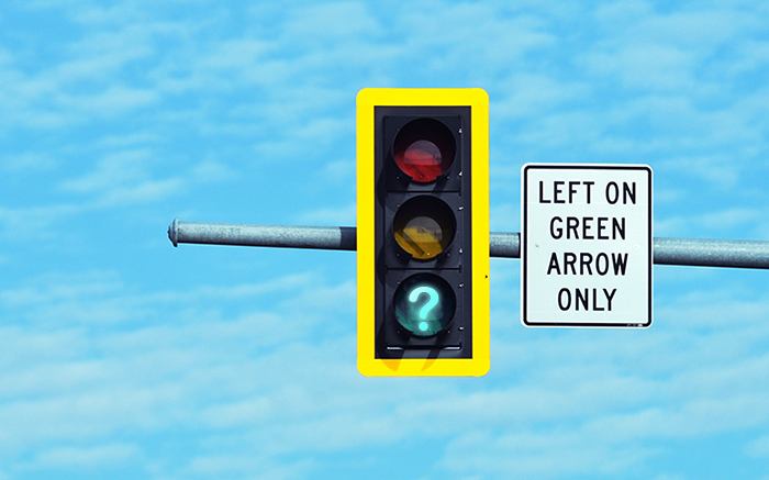 A traffic light with a green question mark in the place of the green light.