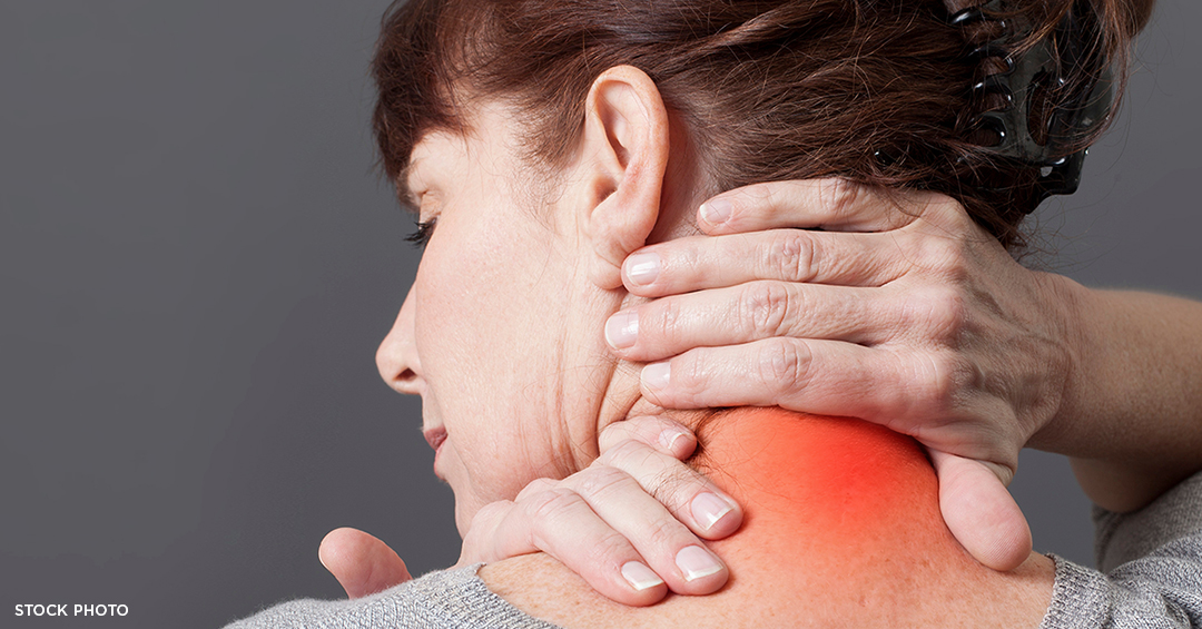 A woman holding her hands over the back of her painful, red showing the area of pain.