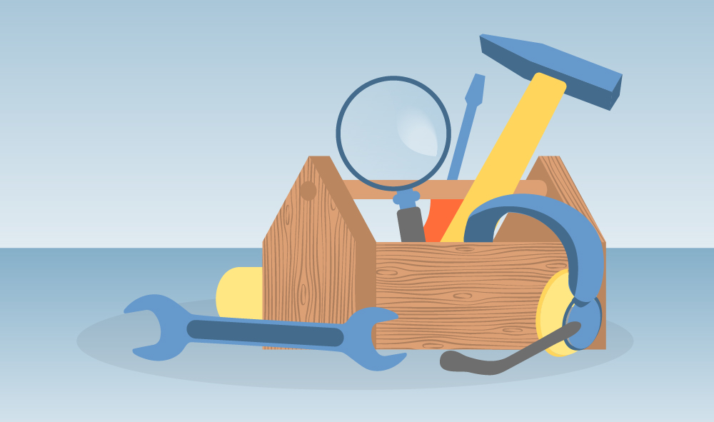 Wooden toolbox containing a hammer, wrench, headset, magnifying glass & screwdriver.