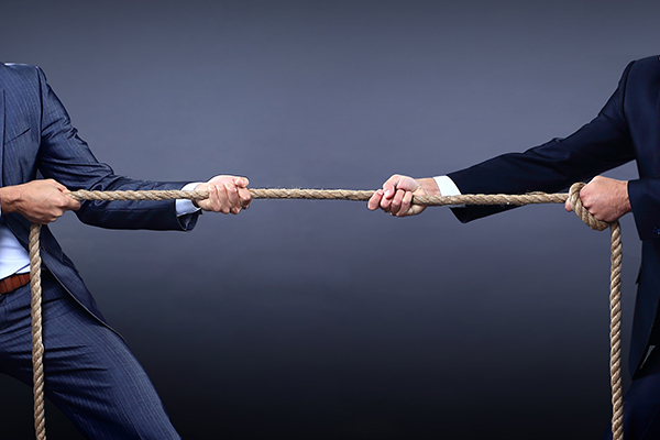 Attorney and insurance adjuster engaged in a tug-of-war, symbolic of the legal process.