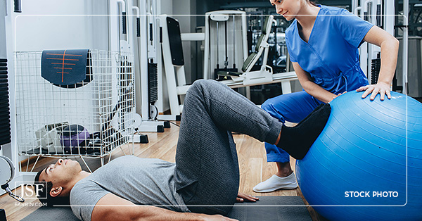 A worker does exercises with the help of a physical therapist.