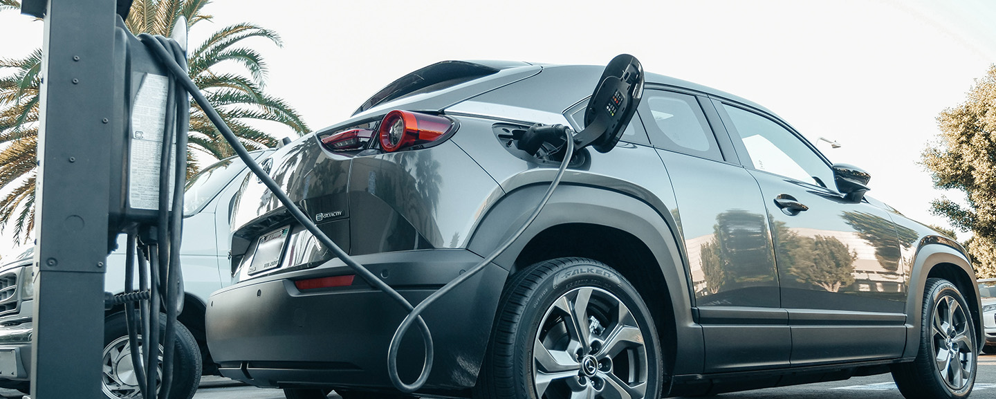 An electric vehicle plugged into an outdoor charging station.