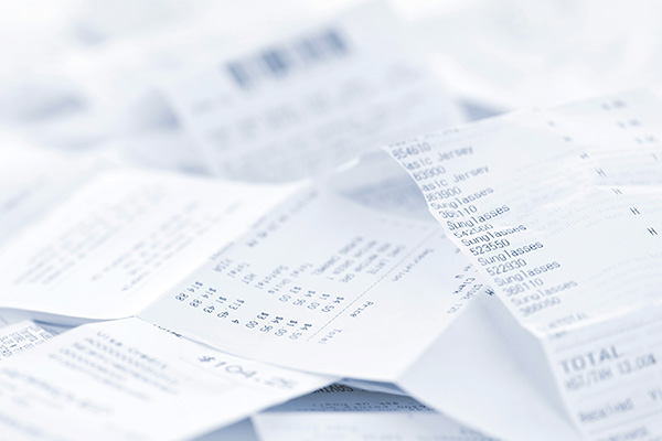 A pile of bills and receipts from expenses following a car wreck.