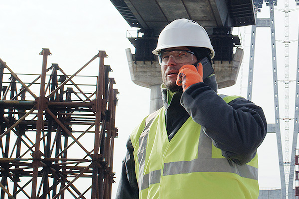 A construction crew lead on his cell phone on a job site.