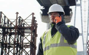 A construction crew lead on his cell phone on a job site.