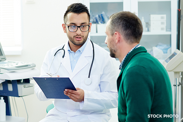 Doctor having a serious discussion with his male patient in the clinic.