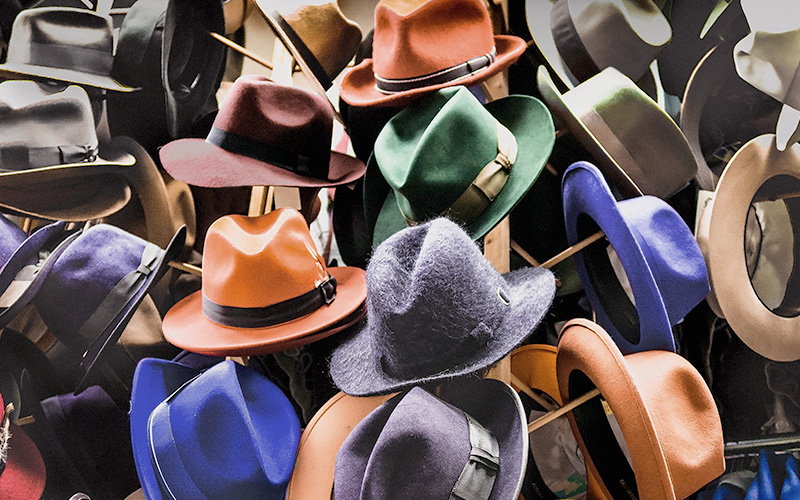 Racks and hangers of dozens of colorful felt men's hats.