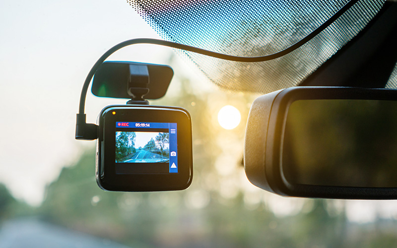 A dash camera mounted to the windshield of a car.