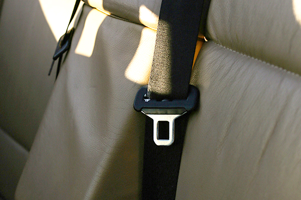 A seat belt buckle in the empty backseat of a car.